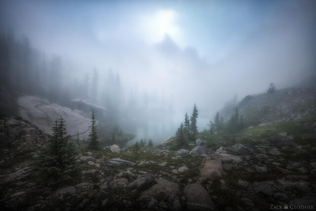 Foggy morning in remote alpine cirque in the Idaho Rocky Mountains at sunrise