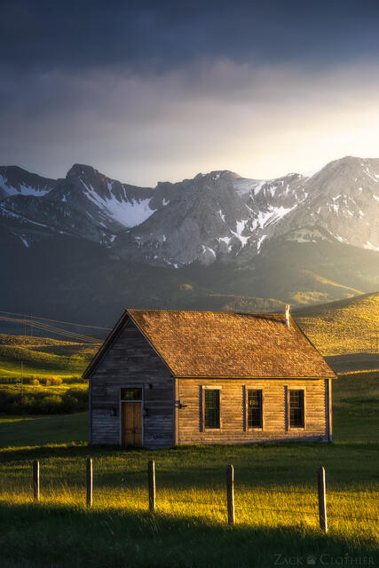 An old, historic church stands steadfast in the fading light of a spring evening, in Montana's Shields River Valley, as the Bridger Range towers above.