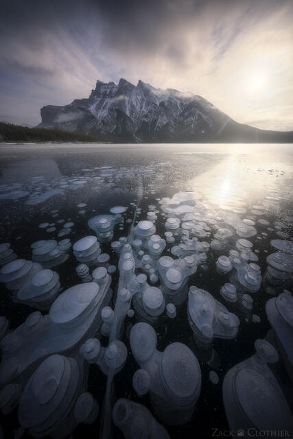 Methane bubbles trapped in the winter ice on Lake Minnewanka, in the Canadian Rockies in Banff, at sunrise.