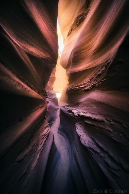 A narrow glowing slot canyon in the remote Utah desert